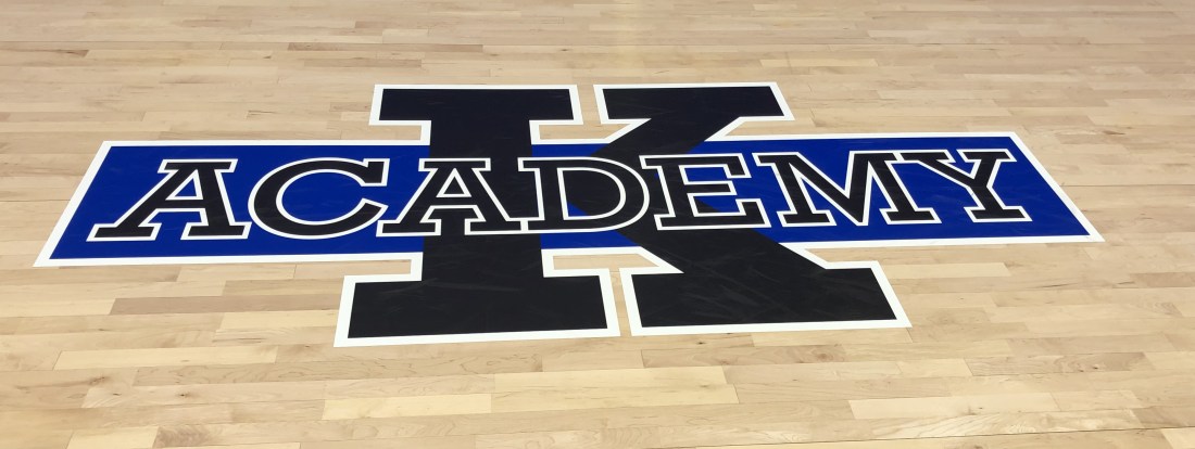 K Academy logo on a basketball court
